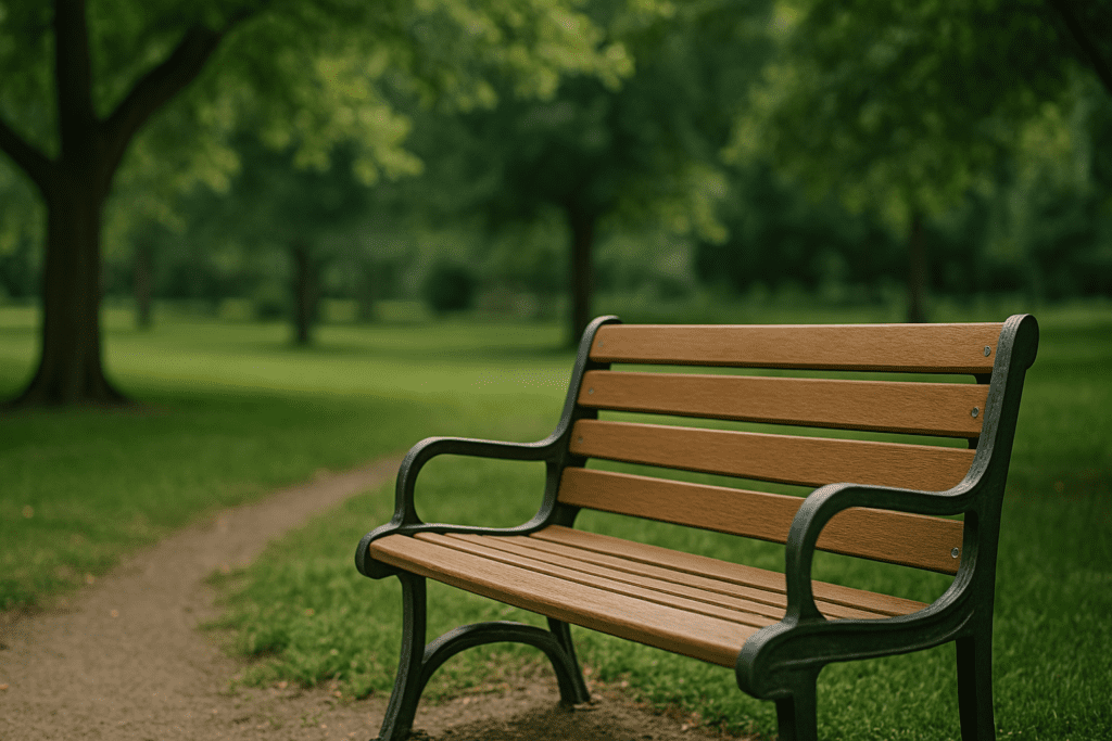 A wooden bench in a quiet park under dappled sunlight, surrounded by trees and greenery in a peaceful outdoor setting